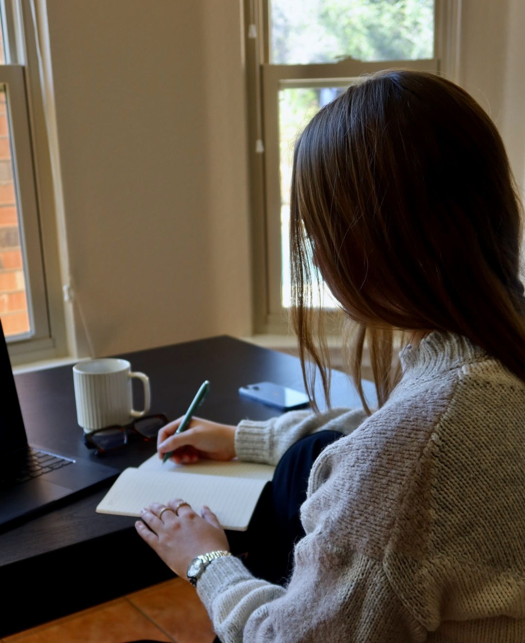woman writing at a desk